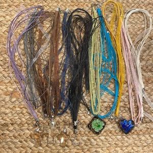 Ribbon and cord necklaces in a variety of colors and glass various pendants.